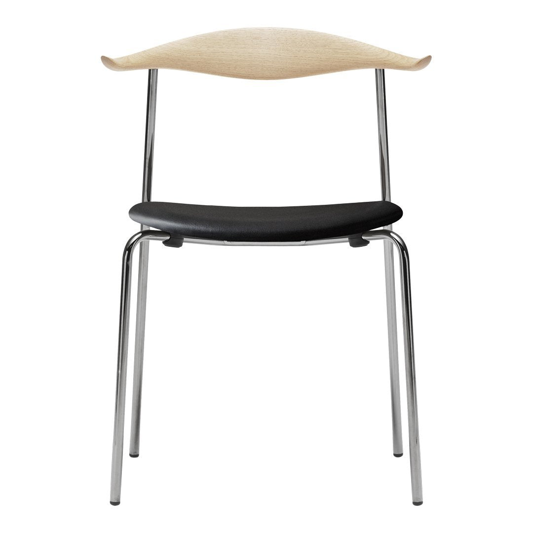 Stylish chair with a light wood backrest, black seat, and sleek chrome legs. Modern and minimalist design.