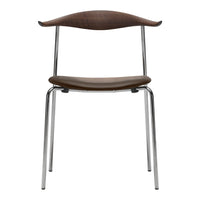 Modern chrome chair featuring a sleek brown wood seat and backrest, showcasing a minimalist design and smooth curves.
