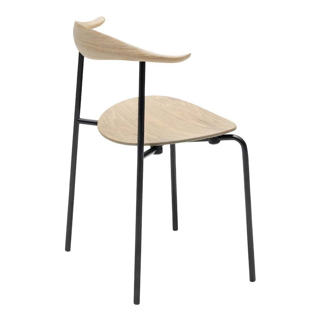 Minimalist chair with a natural wood seat and backrest, complemented by sleek black metal legs.