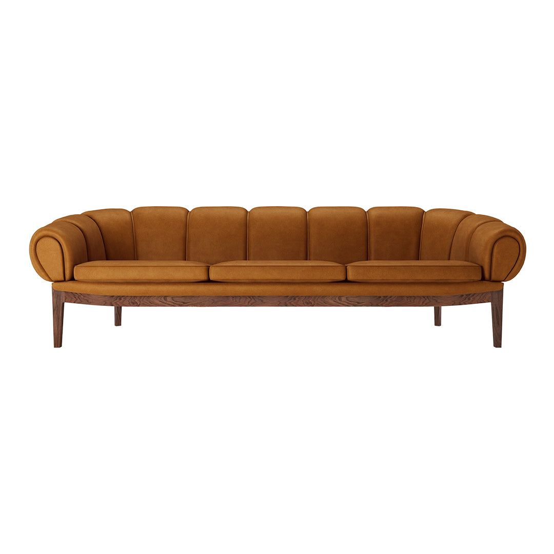 Velvety mustard yellow sofa with rounded arms and ribbed detailing on a wooden base. Ideal for stylish living spaces.