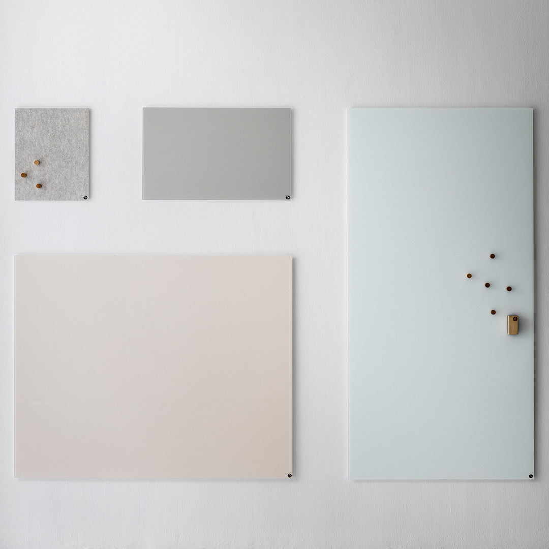 Minimalist wall boards in light gray, soft pink, and pale blue with natural wood accents.