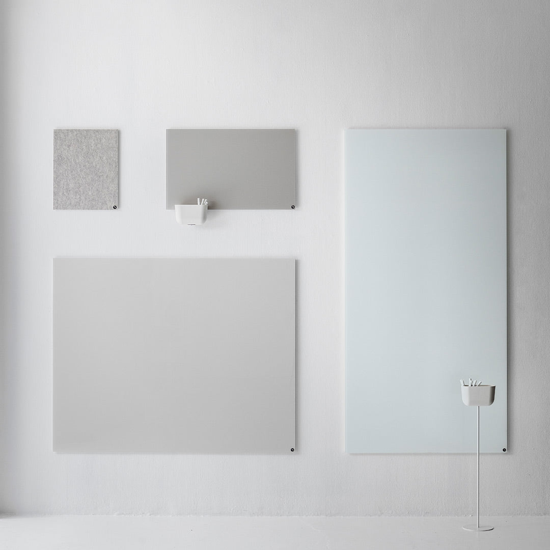"Four grey panels with varying textures displayed on a white wall, featuring smooth and patterned finishes."