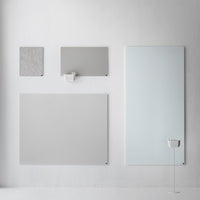 "Four grey panels with varying textures displayed on a white wall, featuring smooth and patterned finishes."