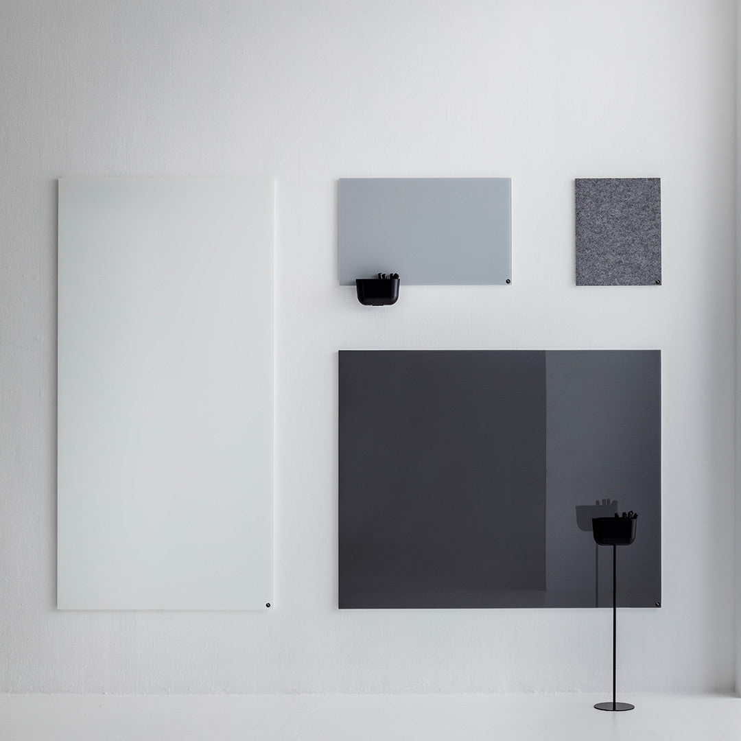 Minimalist wall decor featuring a glossy white, soft gray, textured gray, and deep black panels. Modern color palette.