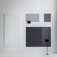 Modern wall panels in white, light gray, dark gray, and textured black patterns, arranged creatively on a minimalist backdrop.
