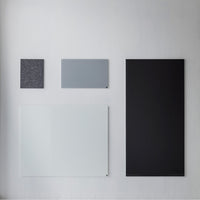 "Four modern board samples in shades of black, gray, and white with varied textures and patterns."