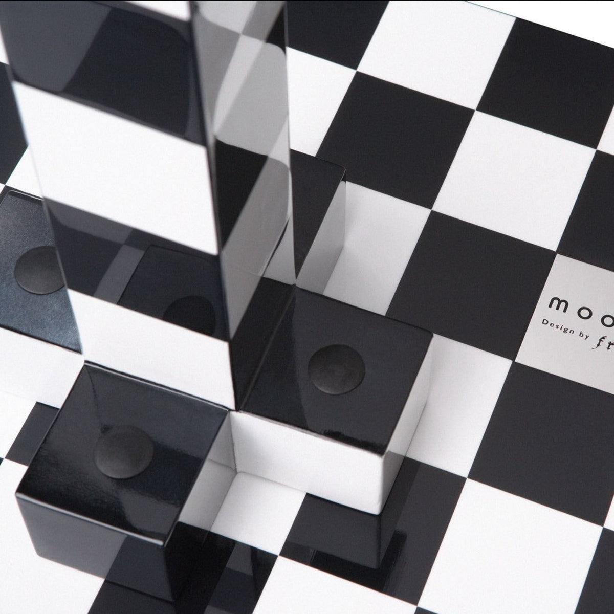Black and white checkered pattern with glossy black blocks and reflective surfaces, creating a modern geometric design.