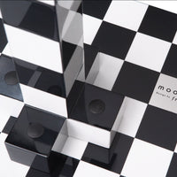 Black and white checkered pattern with glossy black blocks and reflective surfaces, creating a modern geometric design.