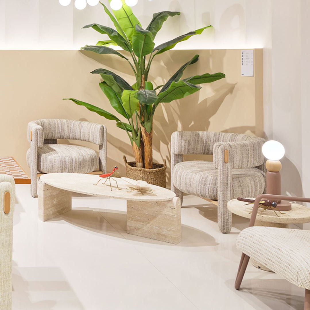 Striped beige and cream chairs, natural wood accents, and a light-colored stone coffee table against a soft beige backdrop.