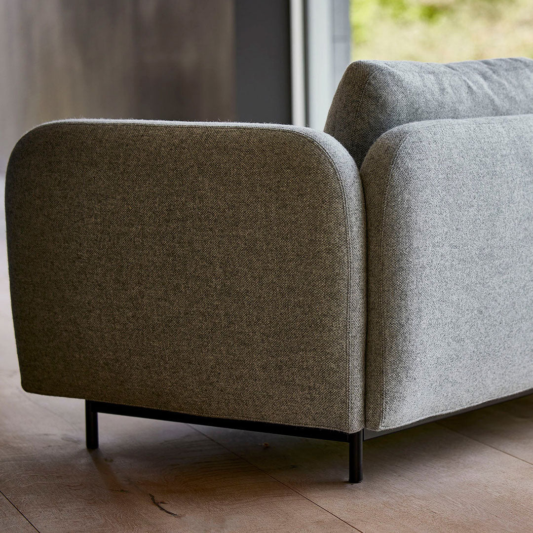 Gray upholstered sofa with a smooth, textured pattern and rounded edges, set on a black metal frame.