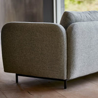 Gray upholstered sofa with a smooth, textured pattern and rounded edges, set on a black metal frame.