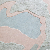 Soft, abstract area rug featuring pale blue, soft pink, and neutral patterns for a modern, stylish home decor accent.