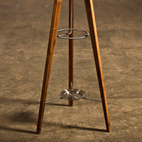 Wooden tripod base with natural brown finish and silver metal accents, showcasing a sleek and modern design.
