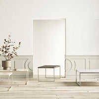 "Minimalist coffee tables in white and gray with sleek metal legs, set against a light, neutral backdrop."