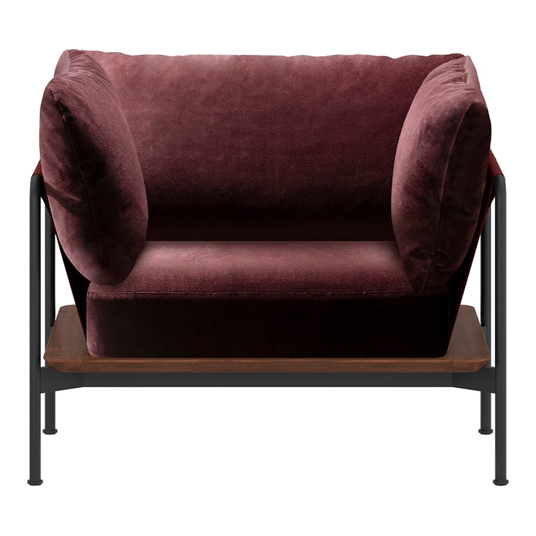 Plush burgundy velvet loveseat with rounded armrests and minimalistic black metal frame, featuring a wood shelf below.