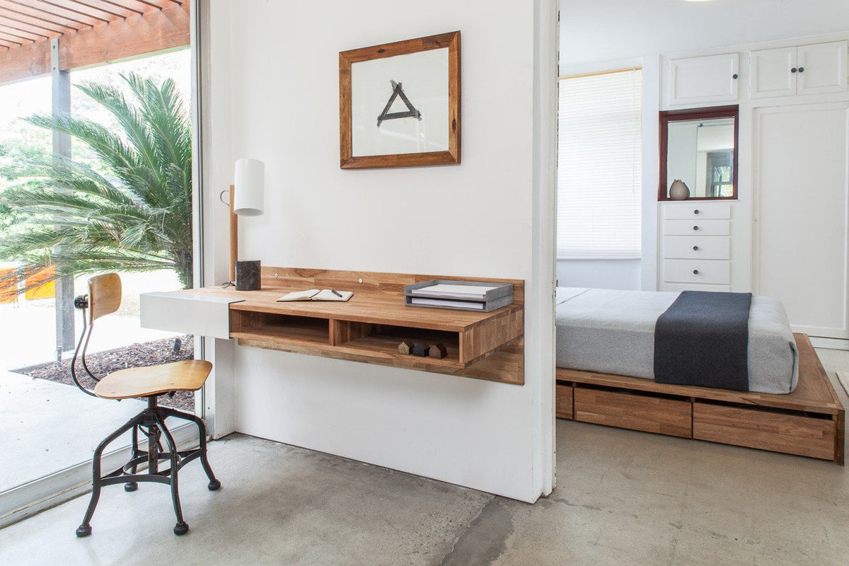 Modern wooden wall desk in natural tones, paired with a white wall and neutral accents, featuring minimalistic design elements.