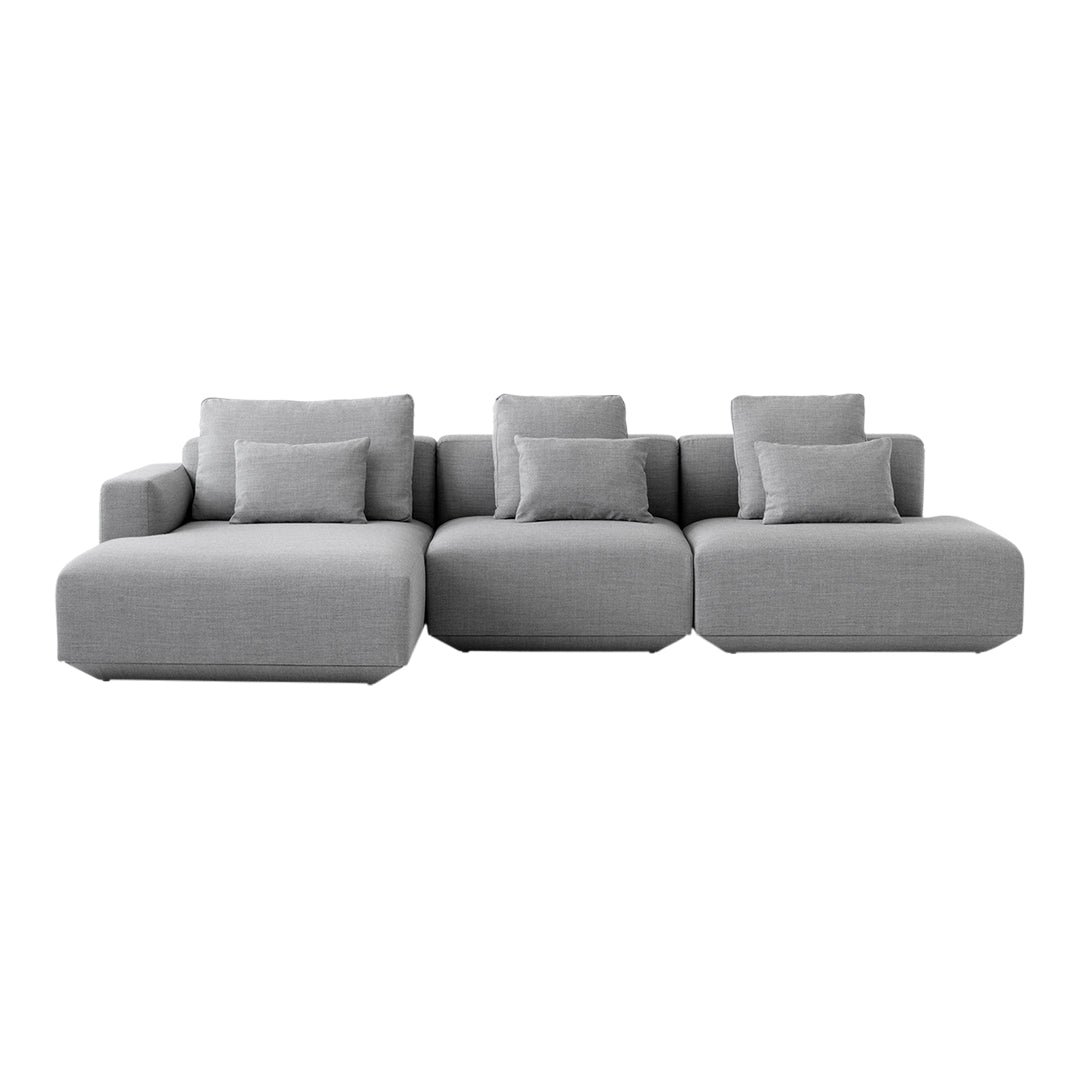 Modern sectional sofa in a soft gray fabric with plush cushions, featuring a sleek, minimalist design.