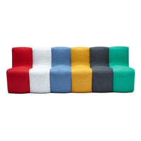 Colorful modern sofa featuring red, white, blue, yellow, gray, and green fabric sections in an abstract pattern.