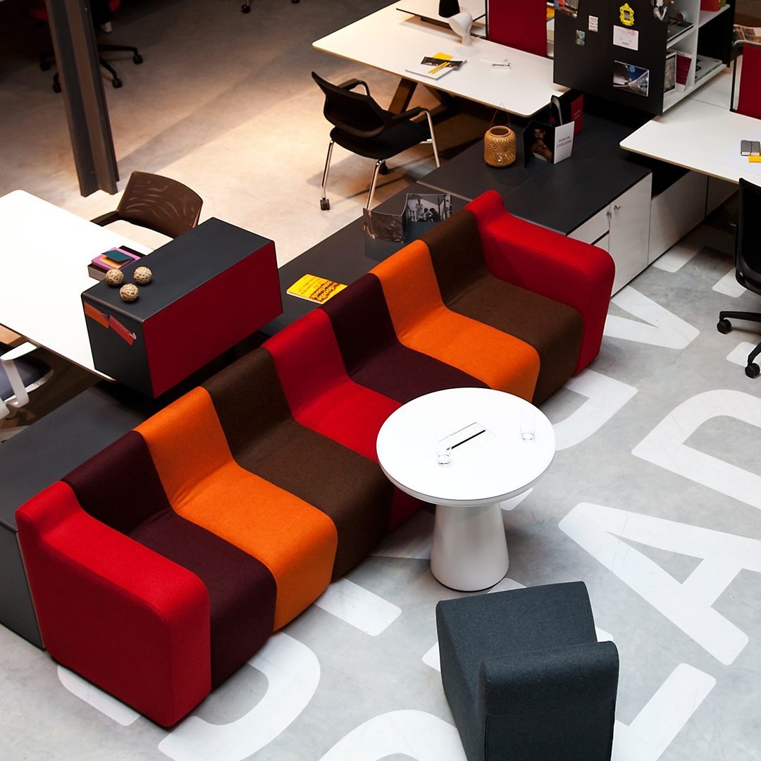 Modern sofa featuring vibrant red, orange, brown, and deep maroon stripes in a stylish pattern. Perfect for any space.