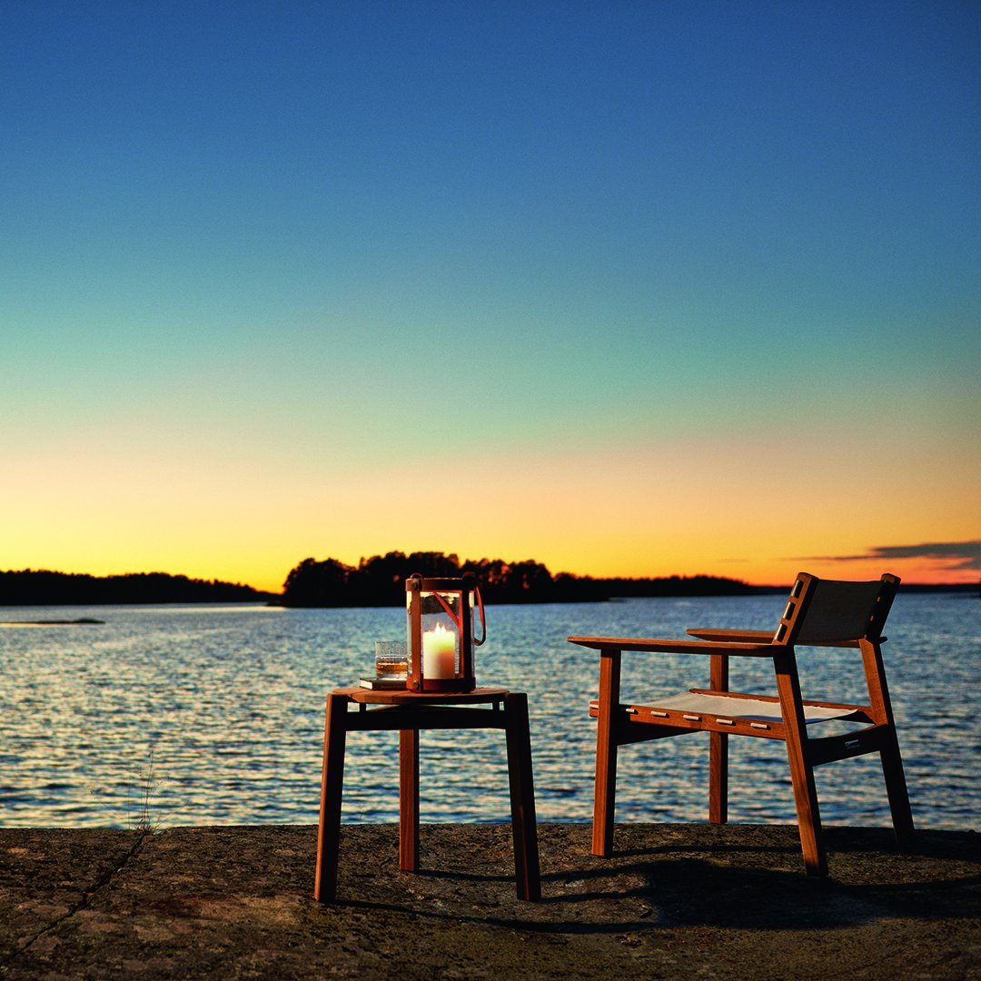 Wooden chairs in warm brown tones against a colorful sunset backdrop with vibrant orange, blue, and purple hues.