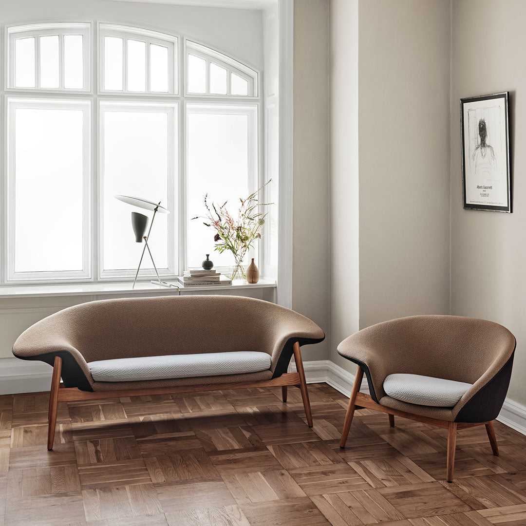 Brown and white modern sofa set with curved lines and wooden legs, enhancing contemporary interior decor.