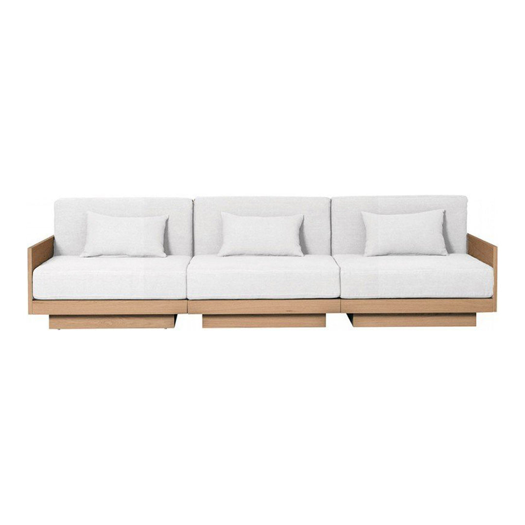 Modern three-seat sofa in soft white fabric with subtle texture and warm wooden frame. Clean, minimalist design.