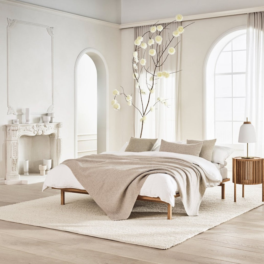 Beige bedding with textured patterns, complemented by neutral tones in a light, airy bedroom.