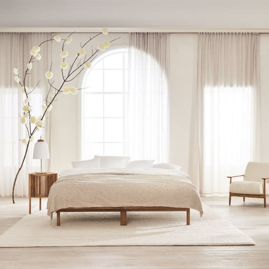 "Neutral-toned bedding set with subtle textured patterns, complemented by soft white and beige accents in a serene bedroom."