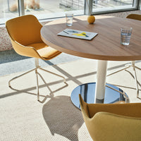 "Light wood table with yellow chairs, gray flooring, and minimalistic decor in a bright, modern setting."