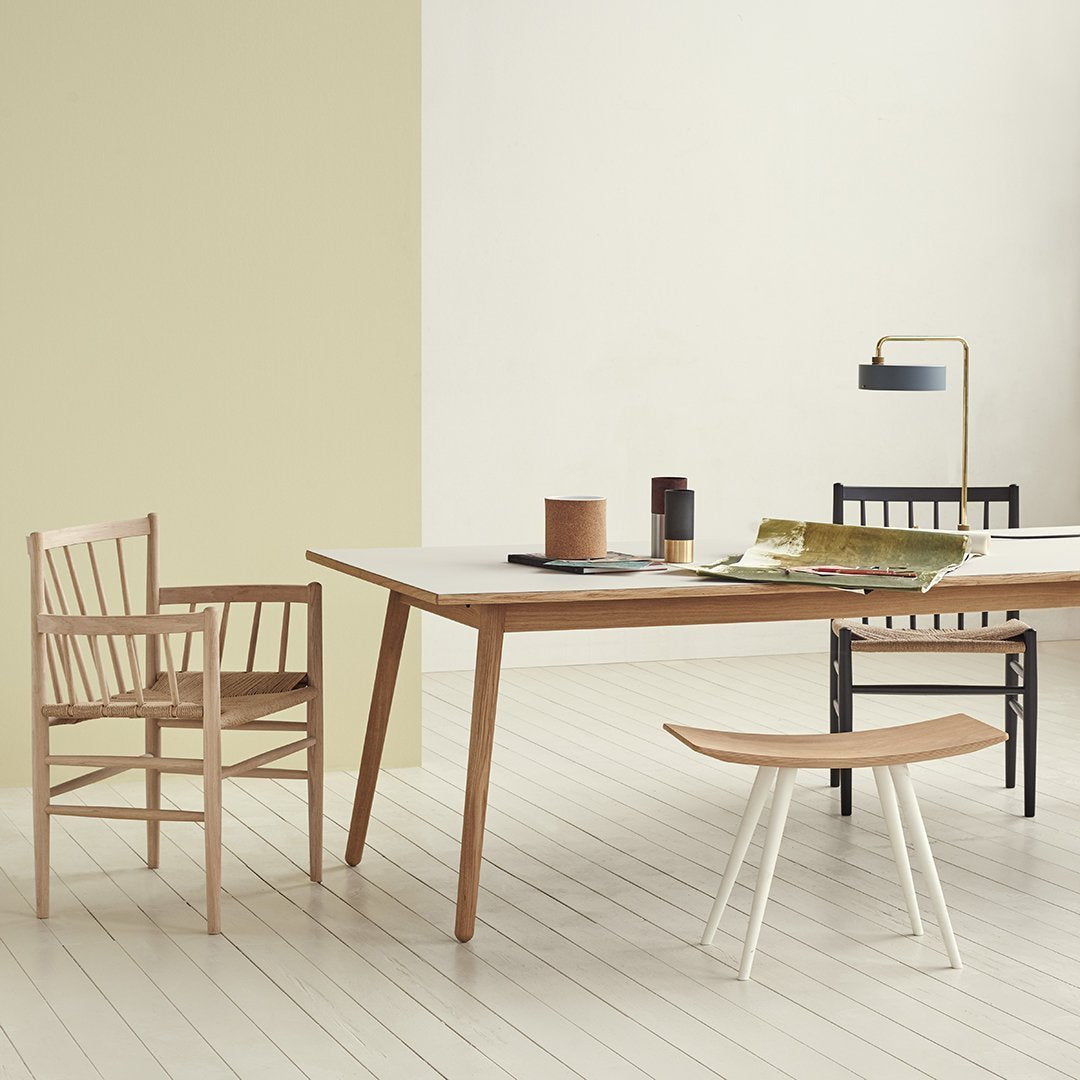 Scandinavian dining set with natural wood tones, beige walls, and minimalist black and white accents.