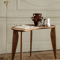 "Elegant wooden table with curved edges, rich brown finish, and minimalist decor against a textured, neutral background."