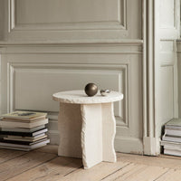 Textured off-white side table with a round top, featuring a rustic finish and subtle natural patterns.
