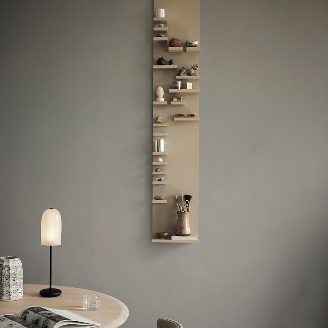 Neutral beige wall-mounted shelf with minimalist decor accents and various textures in soft earth tones.