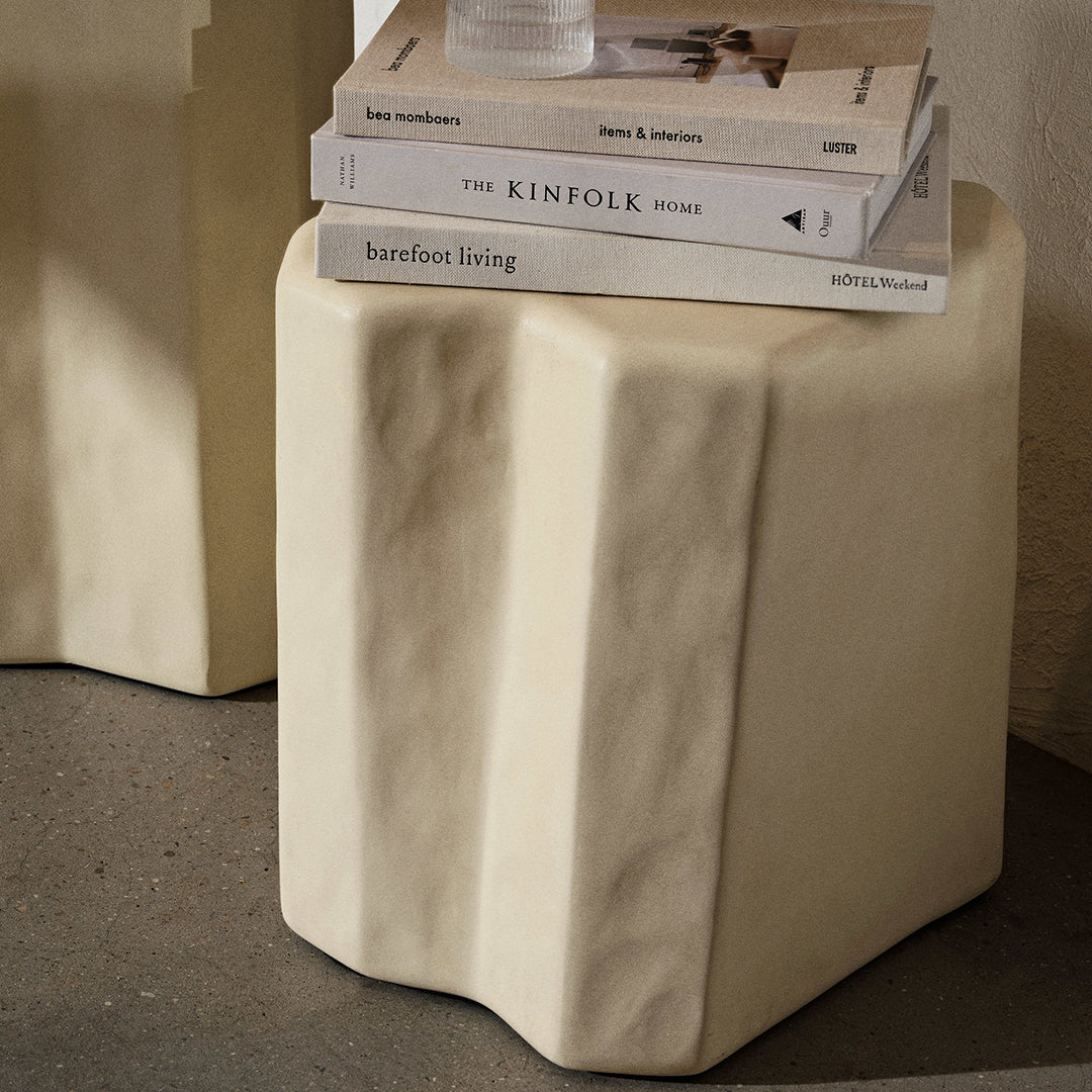 Beige, textured, and sculptural cube side table with subtle ridges, perfect for modern decor.