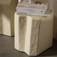 Beige, textured, and sculptural cube side table with subtle ridges, perfect for modern decor.