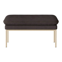 Dark gray upholstered ottoman with gold metal legs, featuring a sleek and modern design.