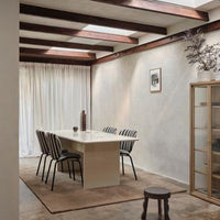 "Modern dining room featuring beige walls, black and white striped chairs, and natural wooden accents."
