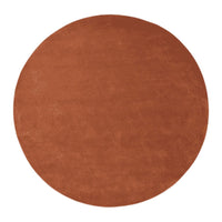 Round terracotta rug with a smooth, solid surface, perfect for adding warmth to any room decor.