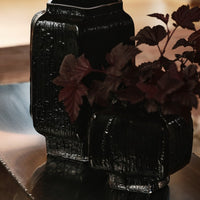 Black textured vases with deep burgundy foliage, showcasing a modern and elegant design. Perfect for home decor.