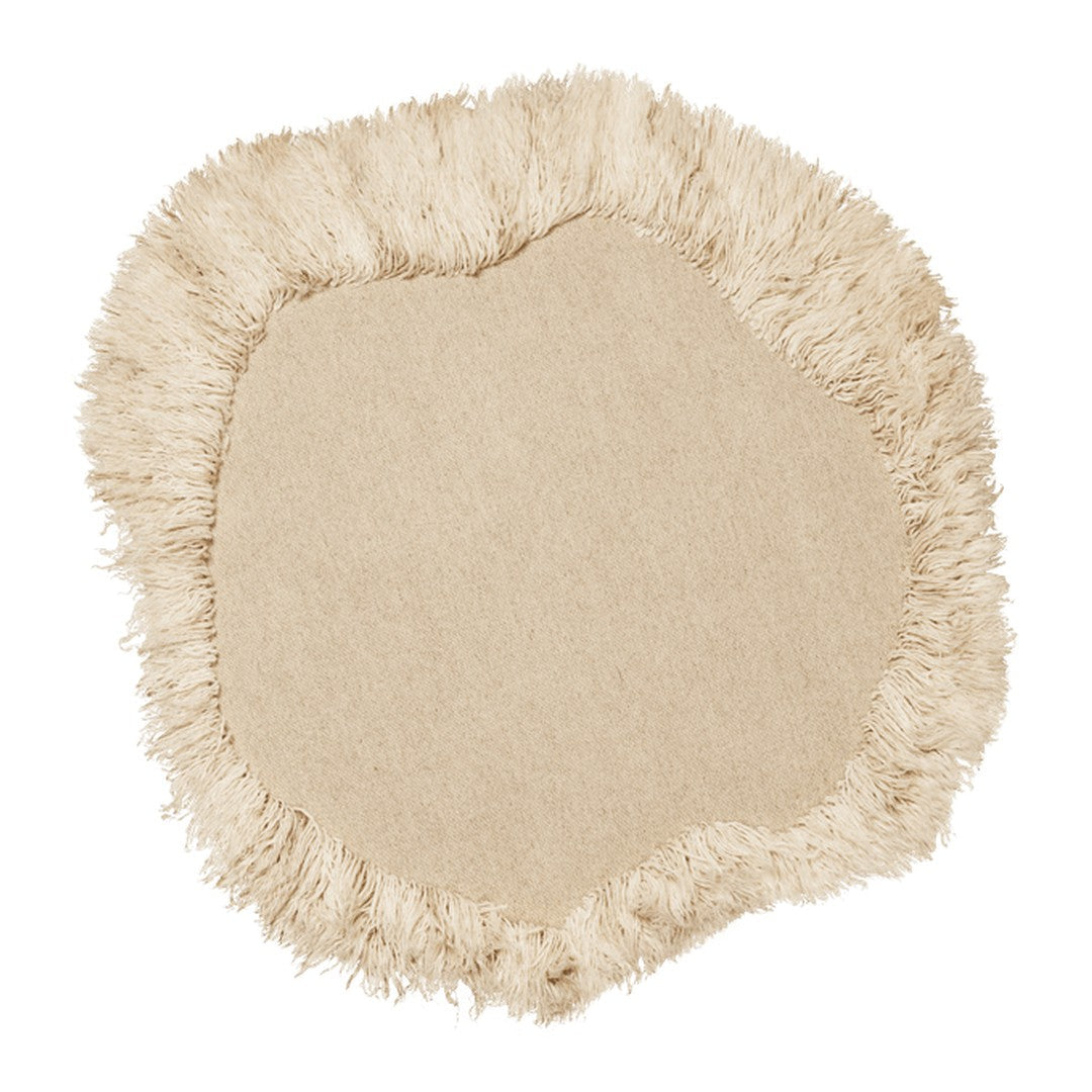 Beige round rug with a fringed edge, featuring a soft, textured surface and organic, asymmetrical shape.