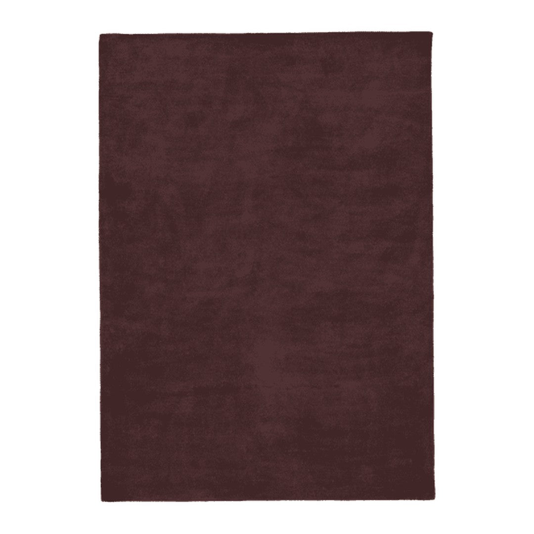 Burgundy solid area rug with a plush texture, perfect for adding warmth and elegance to any space.
