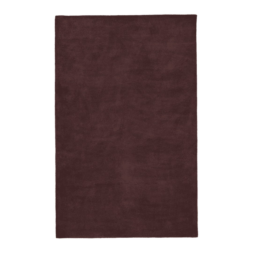 Solid burgundy area rug with a plush texture, perfect for adding warmth and elegance to any space.