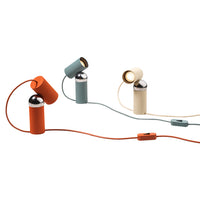 Colorful modern lamps in orange, teal, and cream with sleek metallic accents and playful cord patterns.