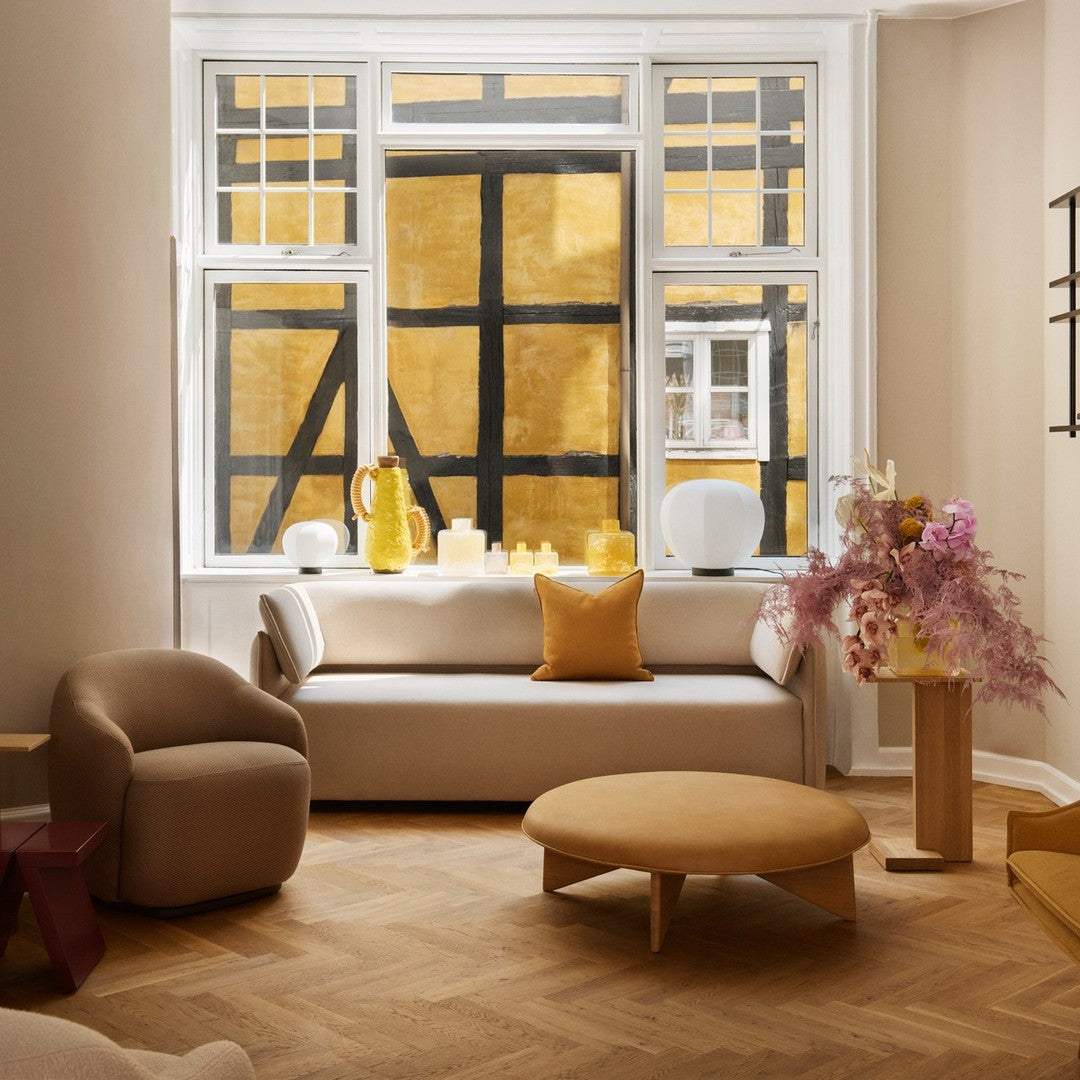 Cozy living room featuring warm yellow accents, soft beige tones, and modern geometric patterns on furniture.
