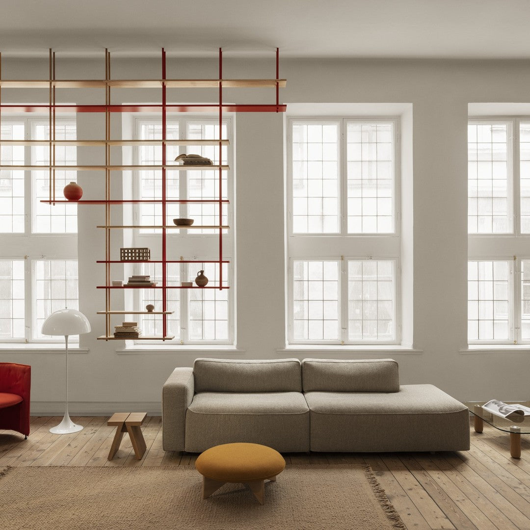 Modern living room featuring neutral tones, red accents, and a mix of textures in decor and furniture.