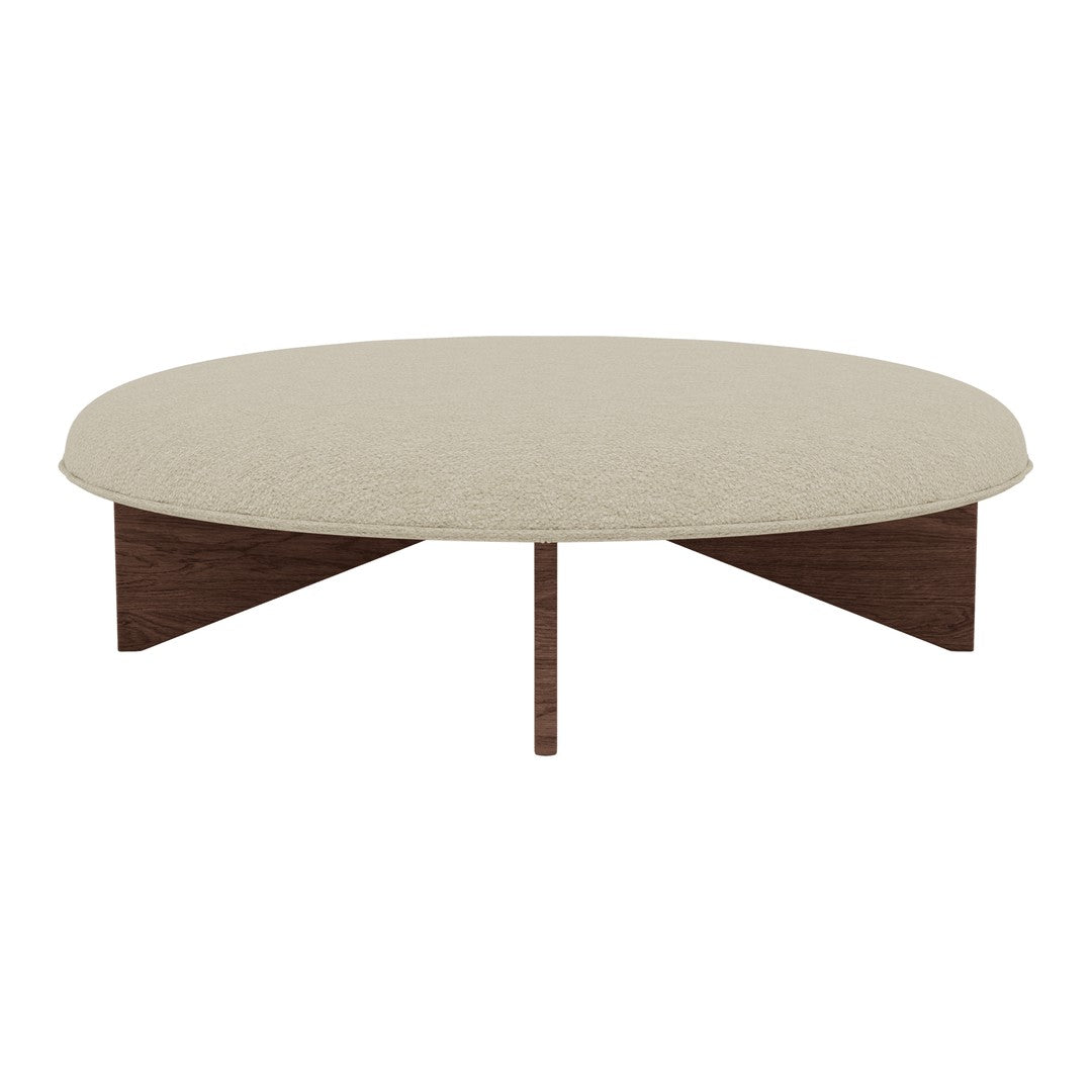 Beige round coffee table with a textured surface and dark brown wooden legs, combining modern style and earthy tones.
