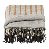 Gray blanket featuring beige stripes and black fringe accents. Perfect for adding warmth and style to any space.