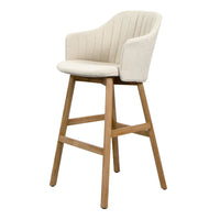Cream upholstered bar stool with ribbed pattern and natural wood legs. Elegant and modern design for any space.