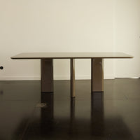 Beige rectangular table with clean lines and smooth surface, set against a minimalist backdrop.