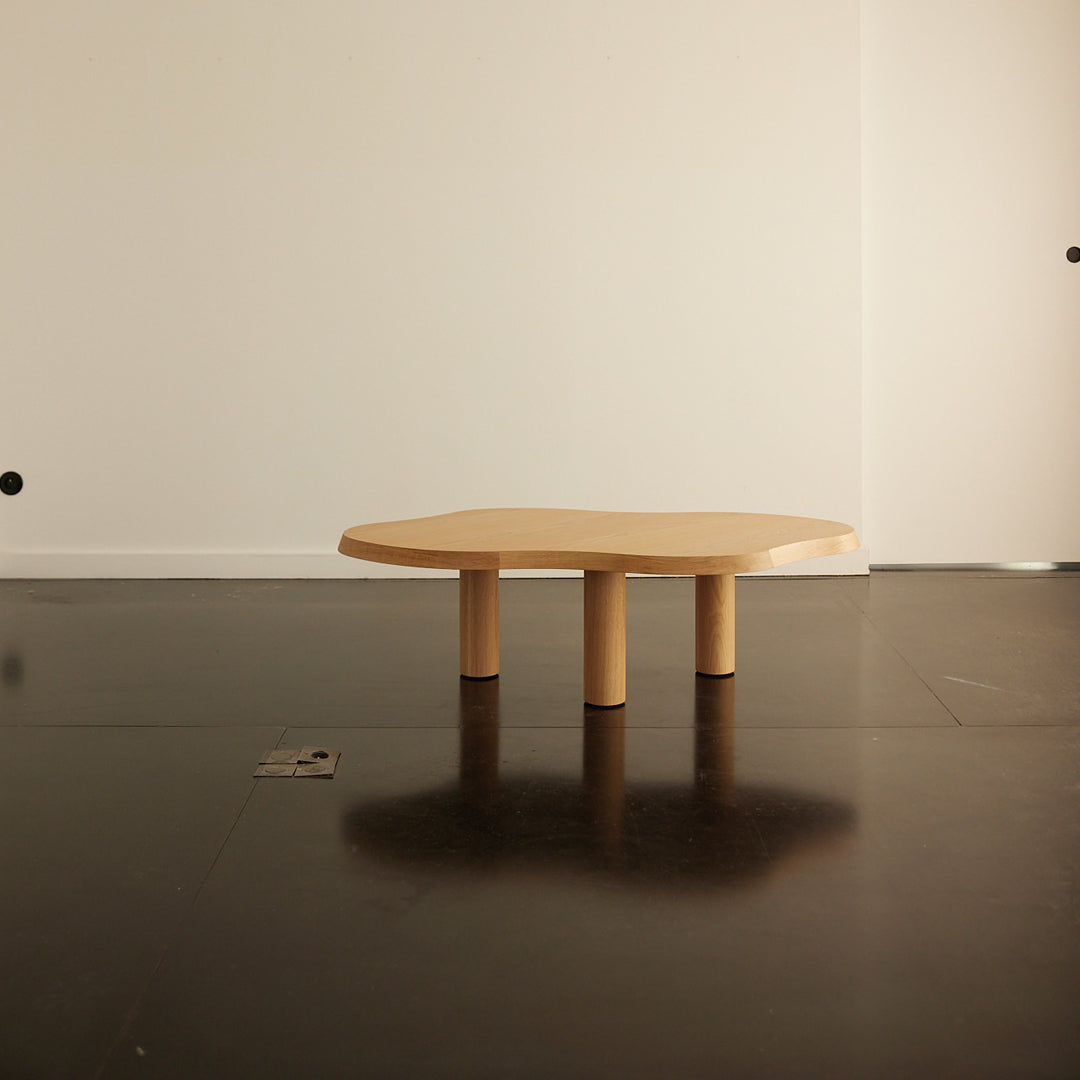 Natural wood coffee table with a unique octagonal shape and smooth, light beige finish. Modern minimalist design.